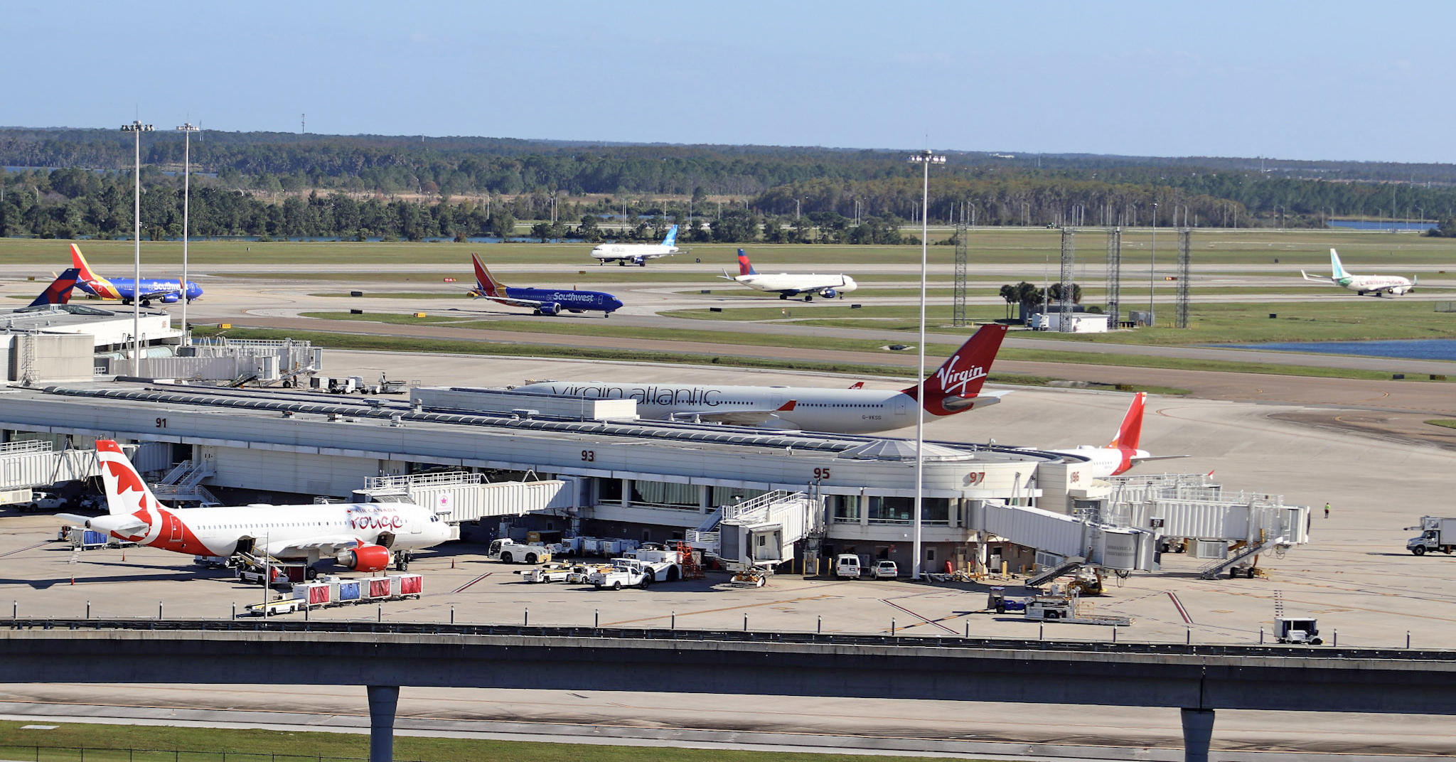 A photo of airlines at a gate at Orlando International Airport.